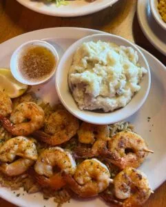 Grilled shrimp with mashed potatoes and dipping sauce.