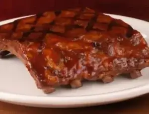 A sidekick portion of tender, glazed ribs served at the Vestal Texas Roadhouse.